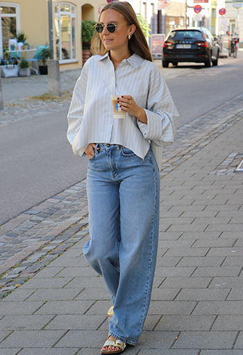 Outfitinspiration am Model: kurze cropped Hemdbluse mit einer wide leg Denim