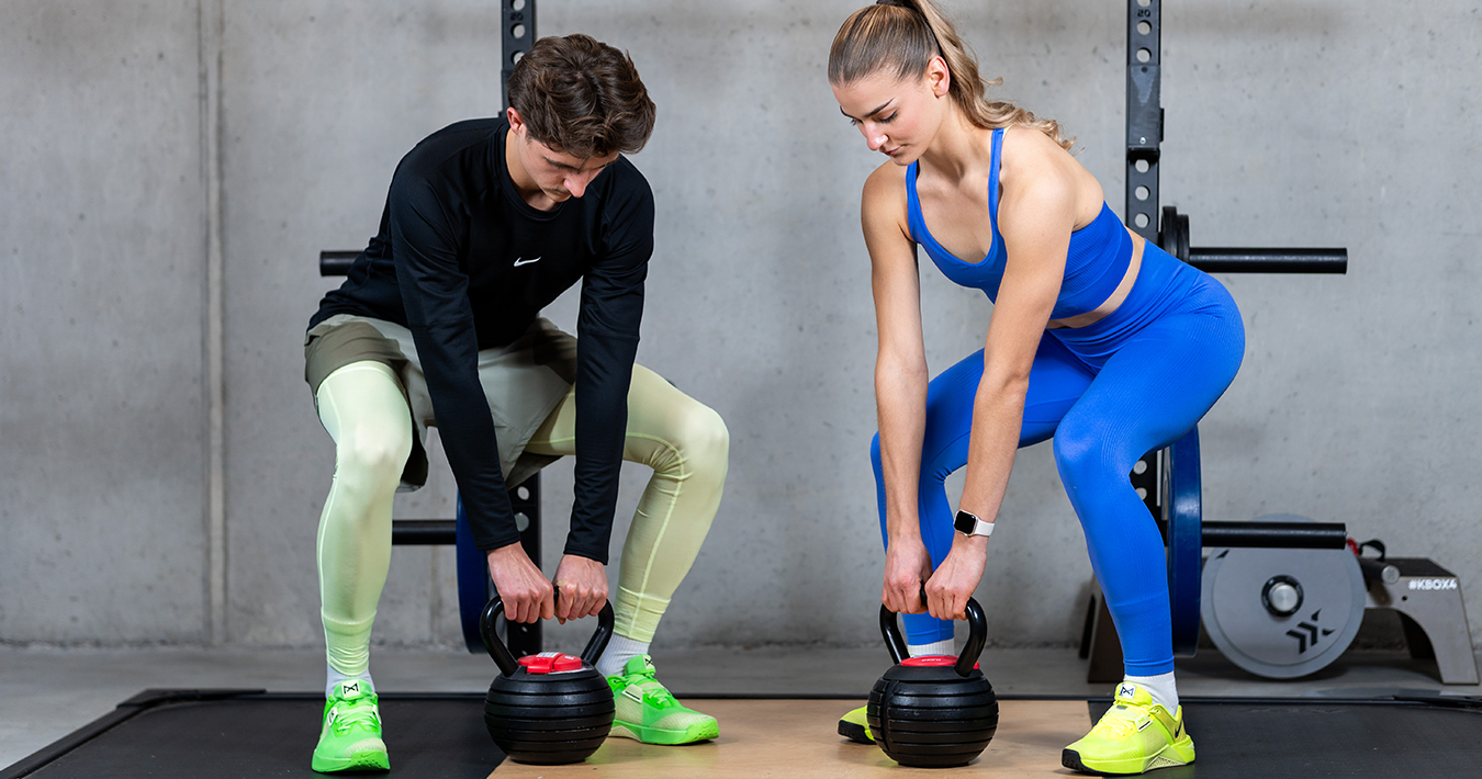 Damen & Herren Fitnessübung mit Kettlebell im Nike Trainingsoutfit Damen & Herren Fitnessübung mit Kettlebell im Nike Trainingsoutfit